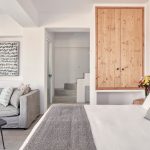 Elysian Santorini Oia Junior Cave House oturma alanı, gri kanepe ve iç merdiven
