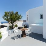 Elysian Santorini Oia villa terası, jakuzi, masa ve uzakta Ege denizi