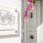 Kampanario Villa Santorini giriş tabelası ve bougainvillea ile süslü ahşap kapı