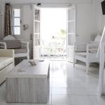 Maistros Village Santorini executive suite oturma alanı, sehpa, kanepe ve iç merdiven