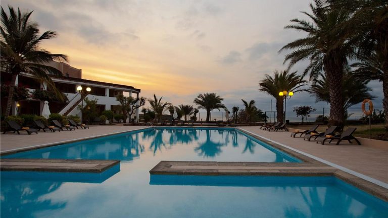 Cape Verde'de palmiyeli otel havuzunda gün batımı