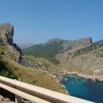 Mallorca turunda Formentor plajının çam gölgeli kıyısı ve arkadaki Tramuntana dağları