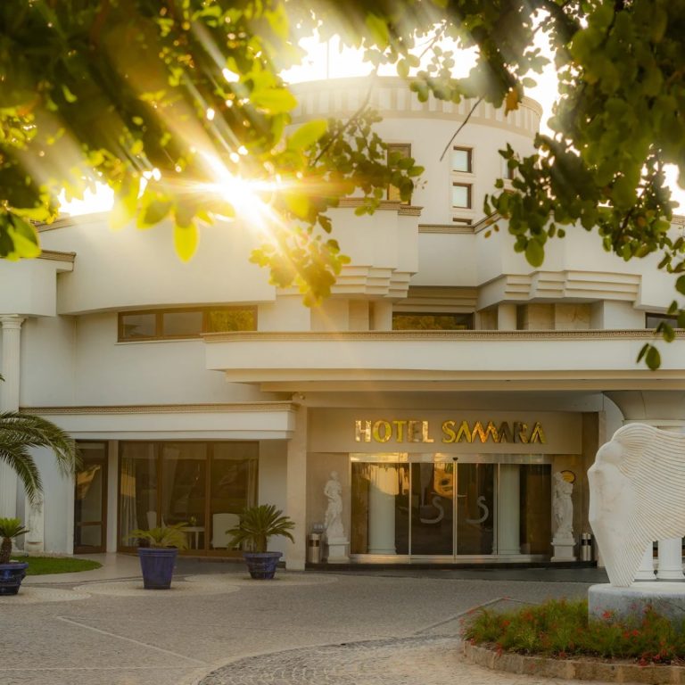 Samara Hotel Bodrum ana giriş cephesi ve ağaçların arasından süzülen gün ışığı