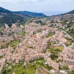 Mallorca turunda Valldemossa'nın dağ eteğine kurulu taş evleri ve manastır kulesi