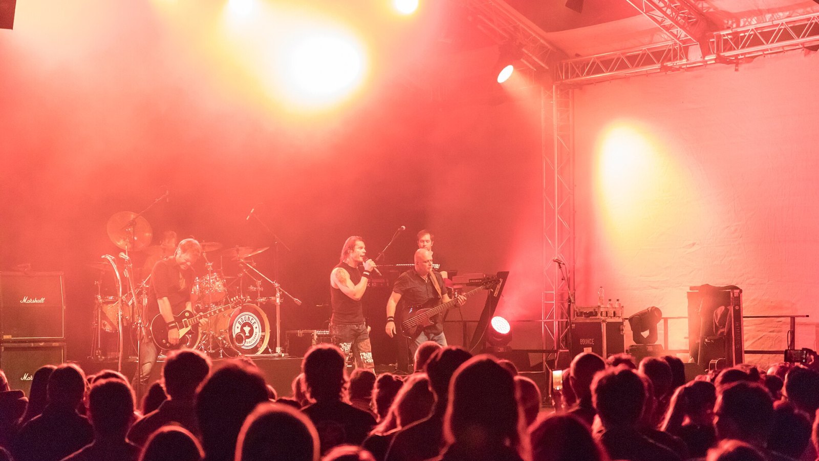 Açık hava konserinde kırmızı sahne ışıkları ve seyirci